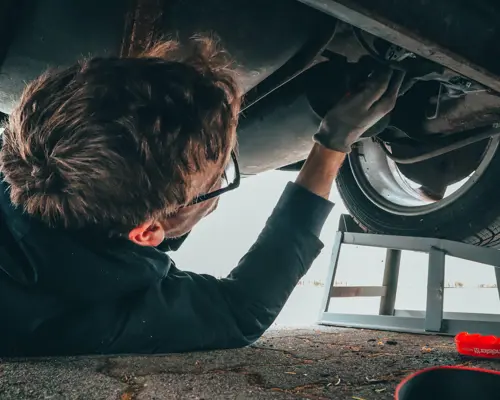 Some guy fixing some vehicle.